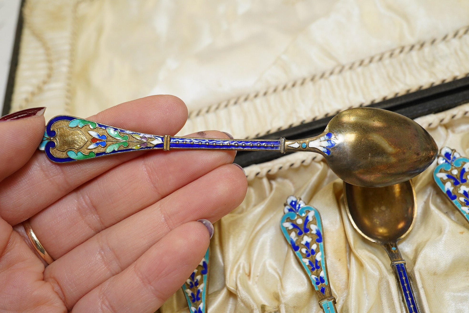 Two sets of Norwegian six enamelled gilt metal and cloisonné enamelled teaspoons, 11.9cm. Condition - poor to fair